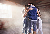 Young dancers in huddle in smoky sunny studio