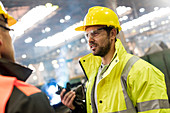 Steel workers talking in factory