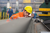 Steel worker examining steel in factory