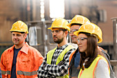 Steel workers listening in meeting in factory
