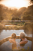 Serene couple in hot tub with autumn view