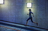 Female runner running ascending urban ramp