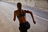 Fit female runner running on urban street
