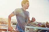 Sweaty male runner running at sunrise