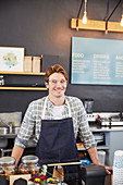 Portrait confident cafe owner at cash register