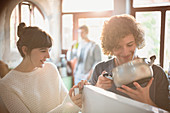 Young couple looking into pot at refrigerator