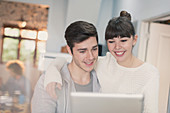 Smiling young couple using digital tablet