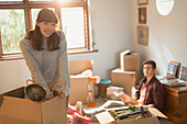 Young couple unpacking moving boxes in apartment