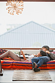 Young couple relaxing using laptop at window