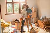 Mother and daughter hugging unpacking boxes
