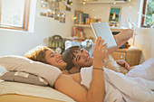 Smiling young couple laying in bed