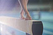 Bare feet of female gymnast on balance beam