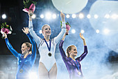 Female gymnasts waving on winners podium