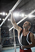 Gymnast applying chalk powder to parallel bars