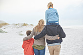 Affectionate family walking on winter beach