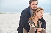 Serene affectionate couple hugging on winter beach