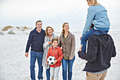 Family with soccer ball on winter beach