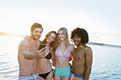 Friends in bikinis and swim trunks taking selfie