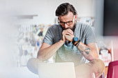 Pensive male design professional working at laptop