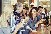 Women friends drinking wine at bar