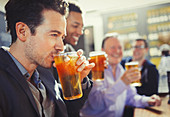 Man drinking beer with friends at bar