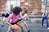 Friends playing basketball on basketball court