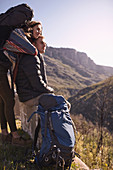 Young couple with backpacks looking at view