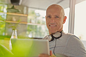 Portrait mature man with headphones and tablet