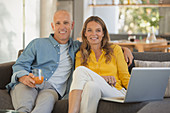 Portrait mature couple using laptop on sofa