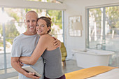 Portrait happy mature couple with tablet hugging