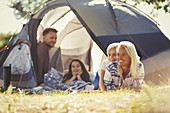 Smiling family relaxing outside tent