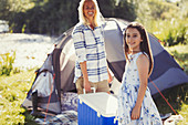 Portrait mother and daughter carrying cooler