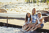 Portrait happy mother and daughters on dock
