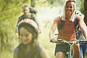 Smiling family mountain biking