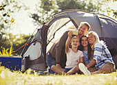 Family taking selfie outside tent