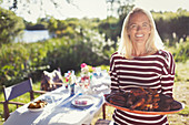 Portrait woman serving platter of food