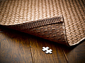 Puzzle piece hidden underneath rug