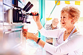 Senior female business owner serving ice cream