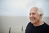 Smiling senior man looking away on beach