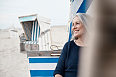 Smiling senior woman looking away on beach