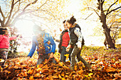 Playful young family playing in leaves in park