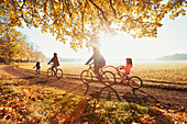 Young family bike riding in autumn park