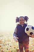 Portrait girl with soccer ball in autumn park