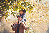 Grandfather carrying daughter on shoulders