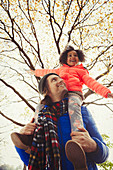 Father carrying enthusiastic daughter on shoulders