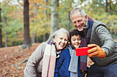 Grandparents and grandson taking selfie in woods