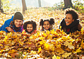Portrait young family laying in autumn leaves