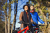 Smiling couple with bicycles in autumn park