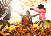 Playful mother and daughters throwing leaves