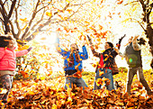 Playful young family throwing leaves in park